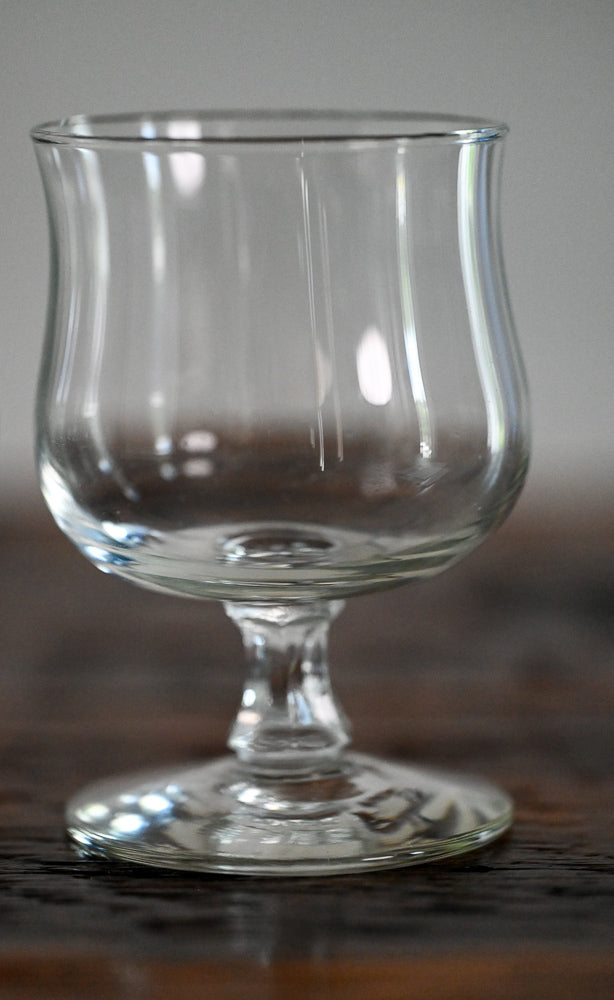 footed glass on wood table