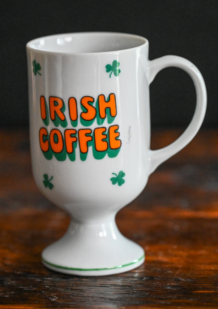 white Irish coffee mug with orange words and green shamrocks