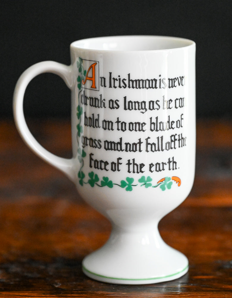 white Irish coffee mug with orange words and green shamrocks