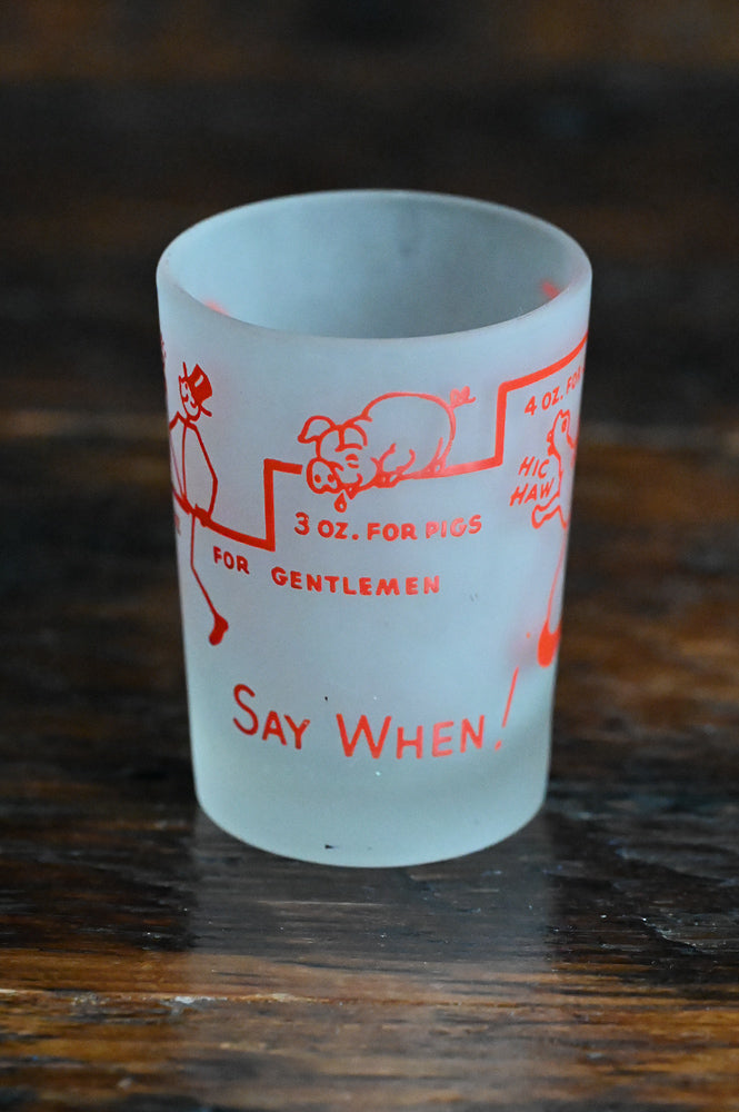 frosted Say When! shotglass with red writing and logos