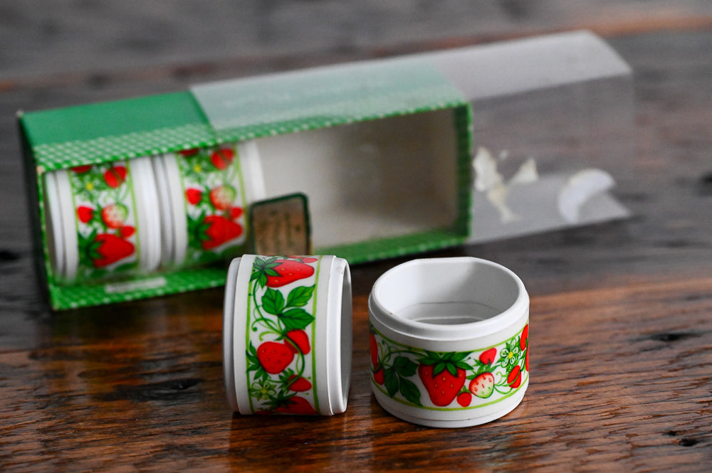 white plastic strawberry napkin rings in original container