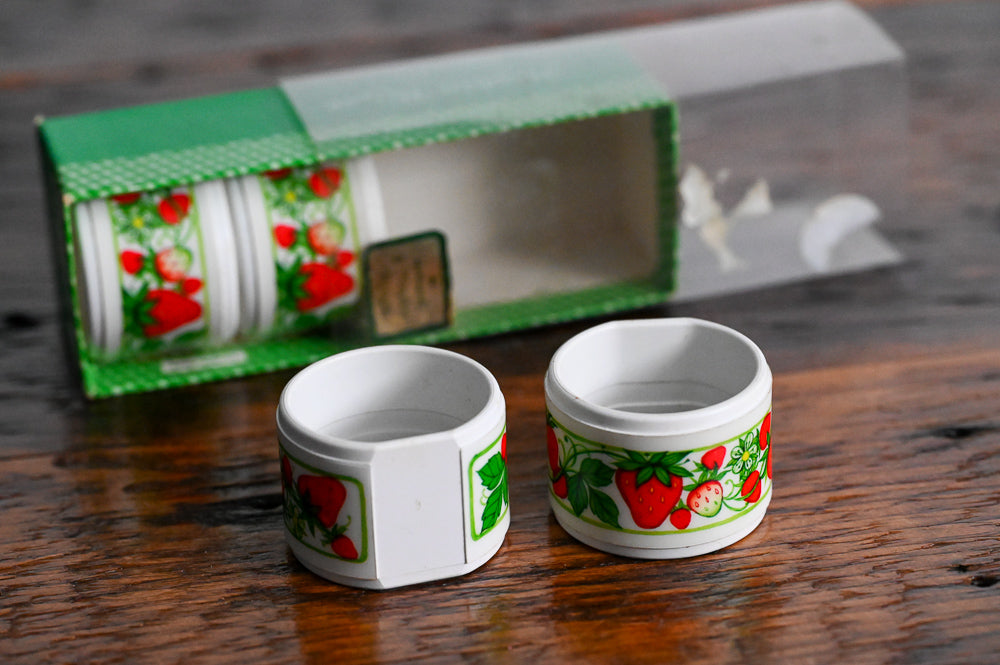 white plastic strawberry napkin rings in original container