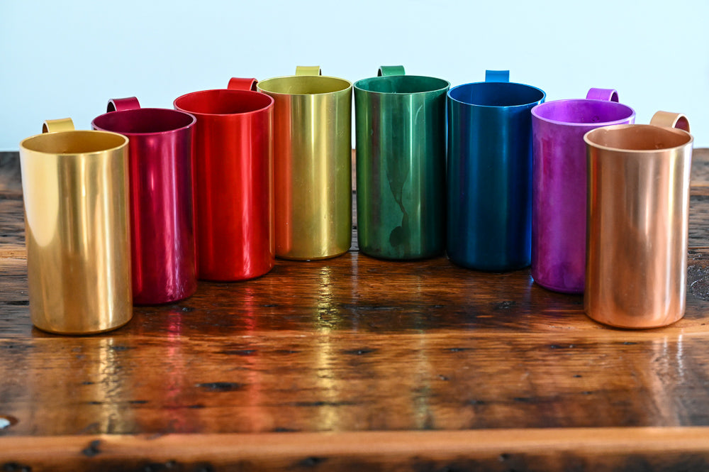 metal mugs on wooden table - gold, maroon, red, yellow, green, blue, purple, rose gold