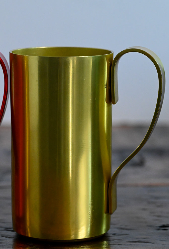 yellow metal mug on wooden table