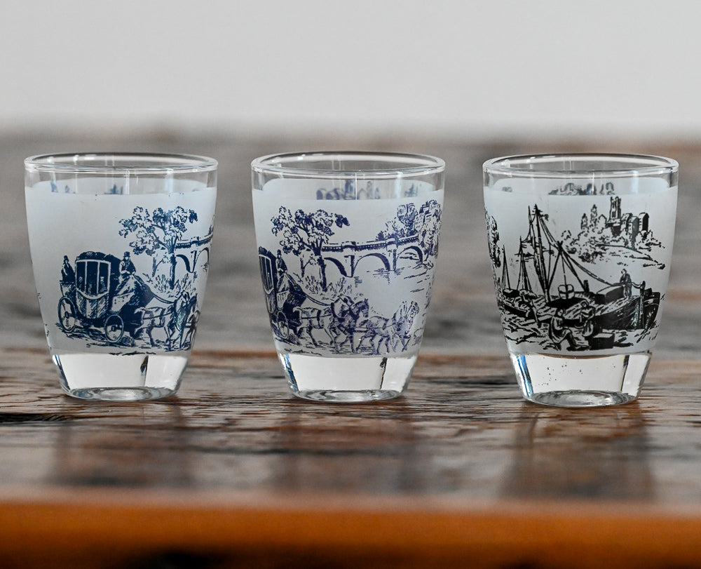 blue and black shotglasses on wood table