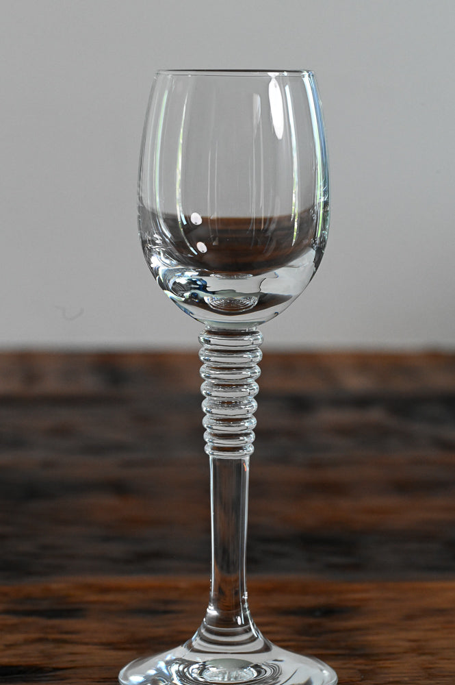 cordial glass with stacked stem on wood table