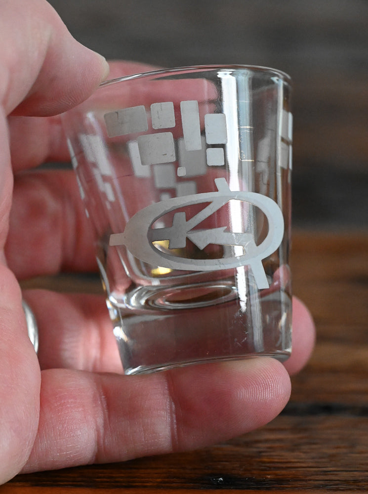 white and gold MCM logo shot glass