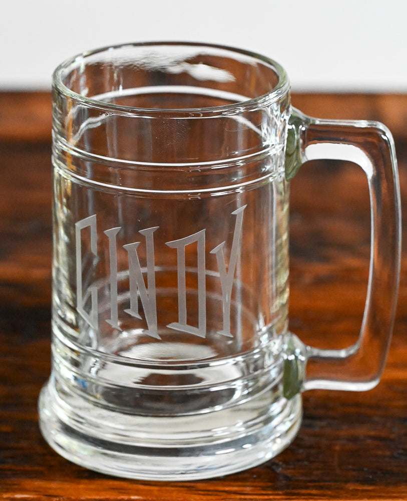 Clear Beer stein etched with "cindy" on wooden table