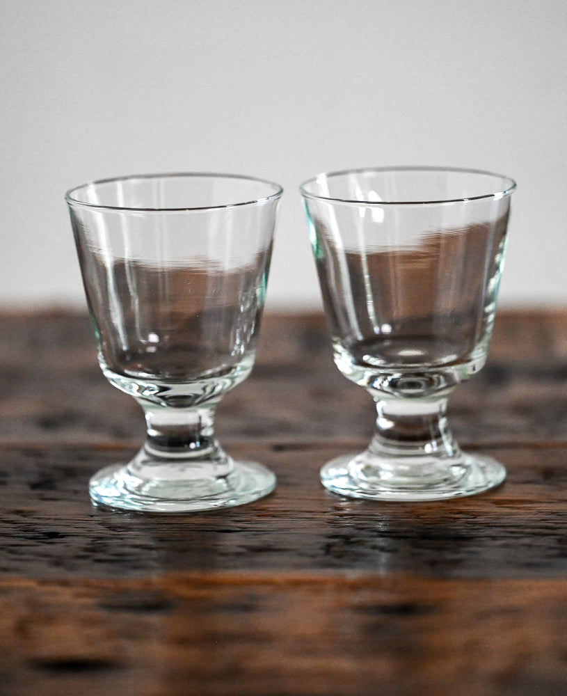 footed clear glasses on wood table