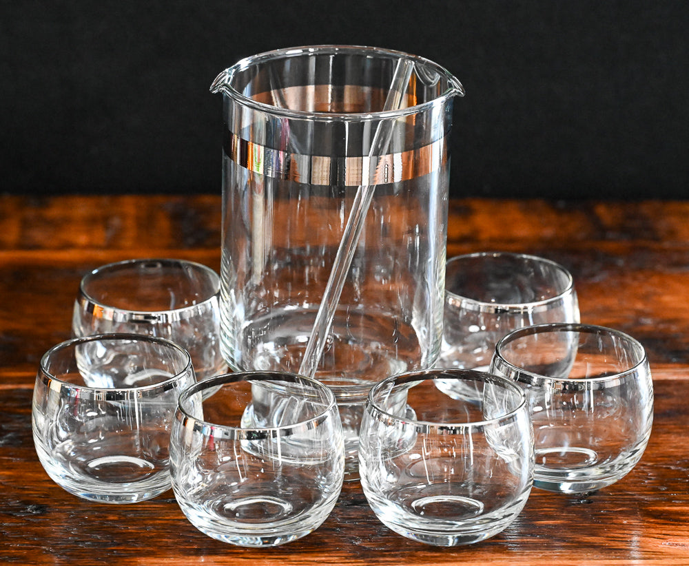 silver banded cocktail pitcher, glass cocktail stirrer and 6 silver rim roly poly glasses