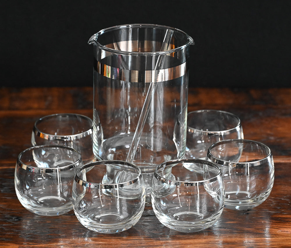 silver banded cocktail pitcher, glass cocktail stirrer and 6 silver rim roly poly glasses