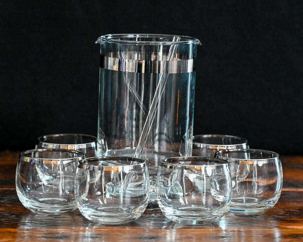 silver banded cocktail pitcher, glass cocktail stirrer and 6 silver rim roly poly glasses