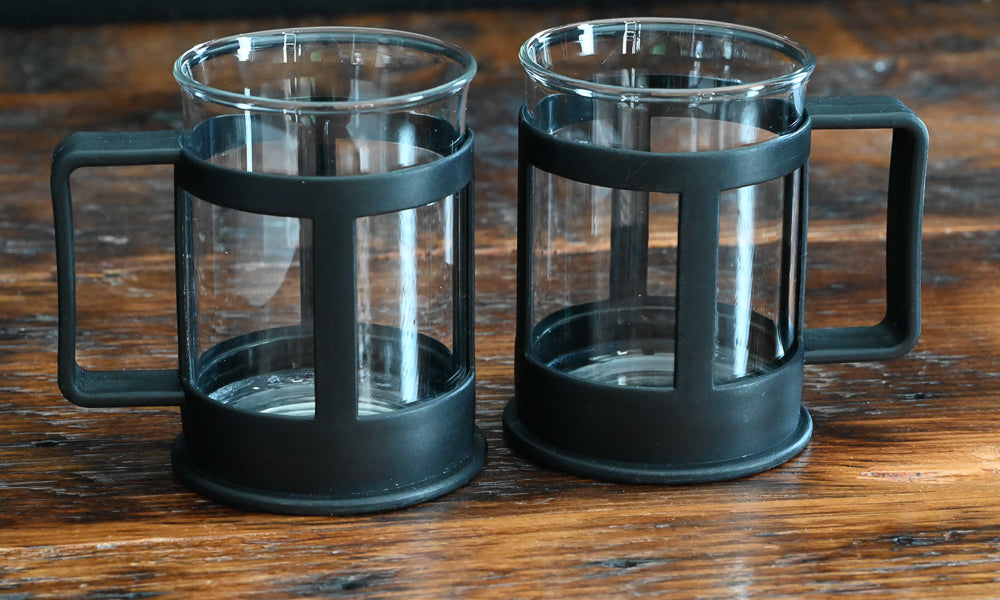 clear glass coffee mugs with black plastic handles and holders