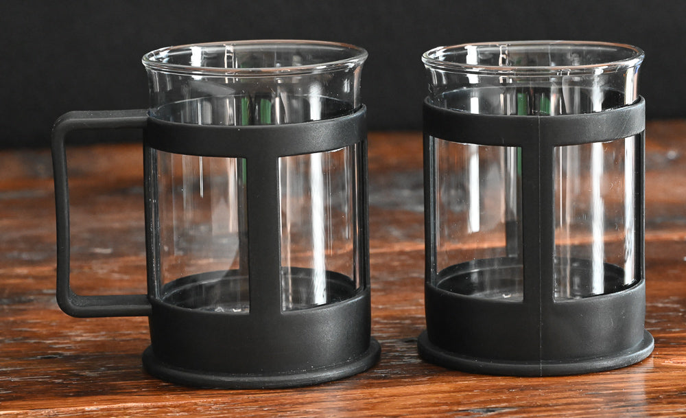 clear glass coffee mugs with black plastic handles and holders