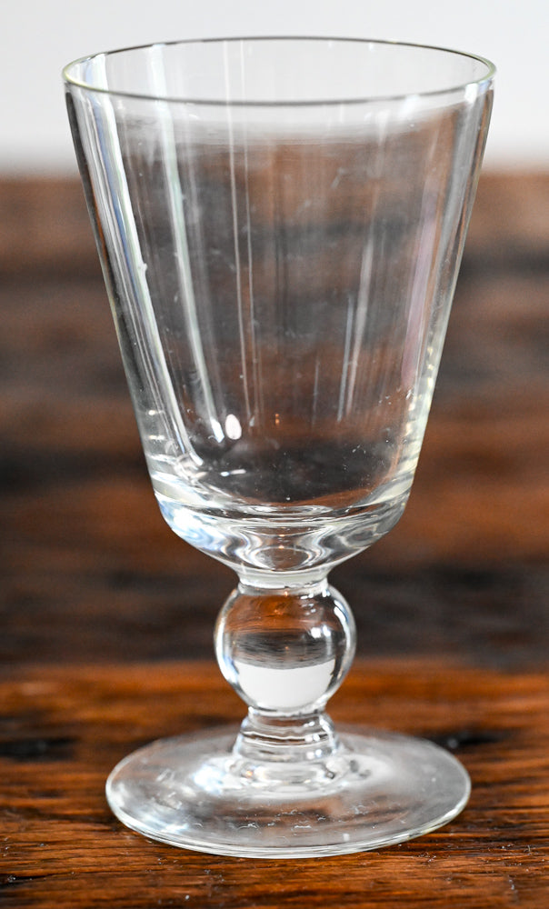 clear glass footed goblet on wooden table