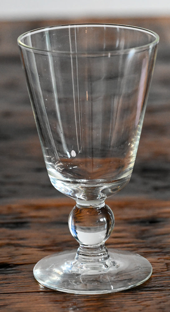 clear glass footed goblet on wooden table