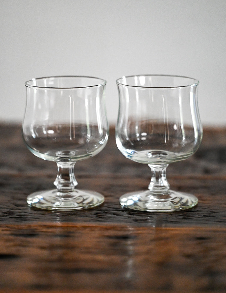 footed glasses on wood table