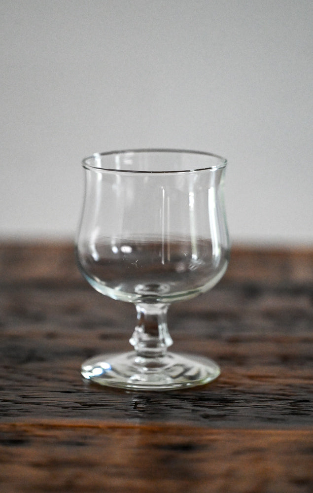 footed glass on wood table