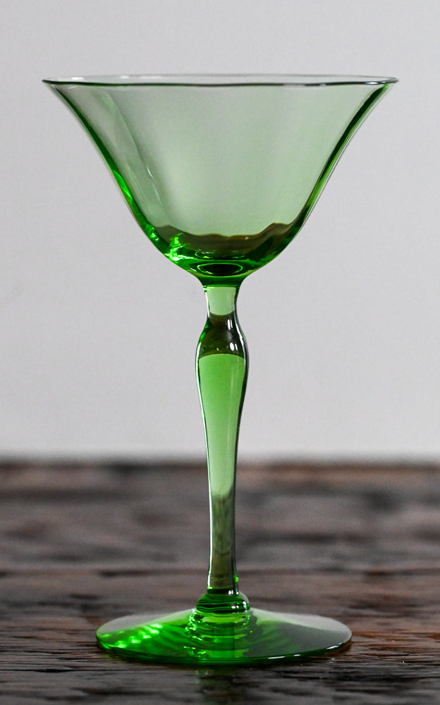 green coupe glass on wooden table