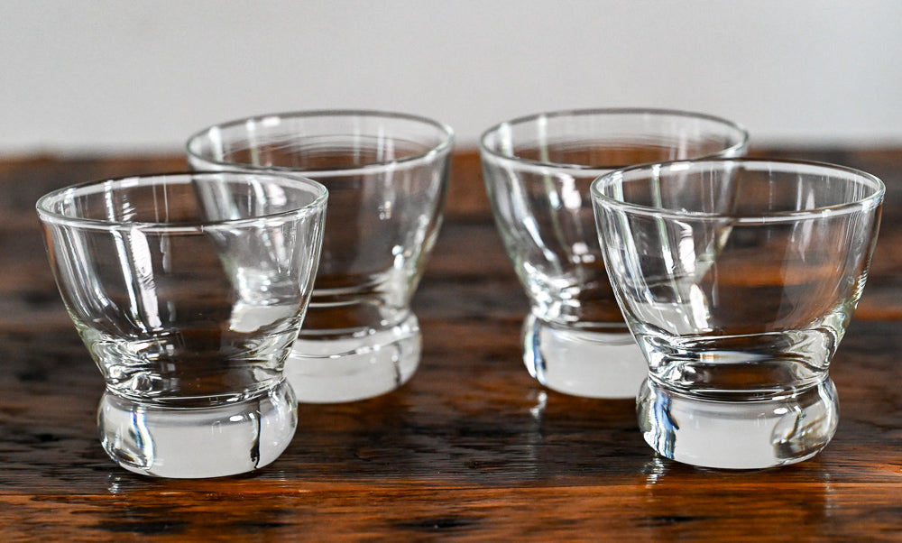 small clear glasses on wooden table