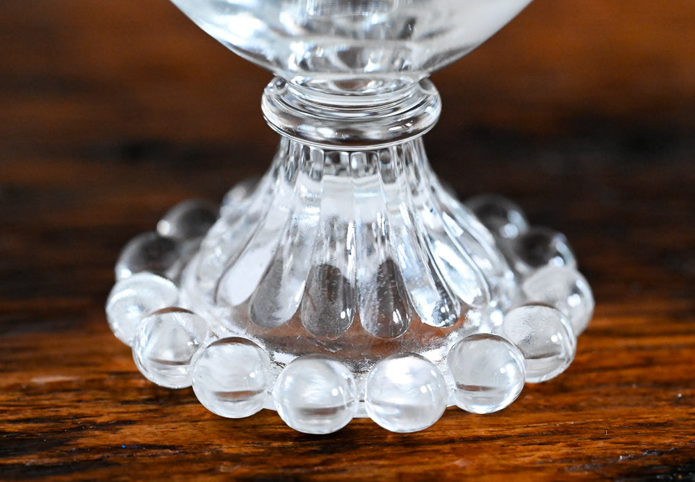 clear glass with glass balls on foot of glass
