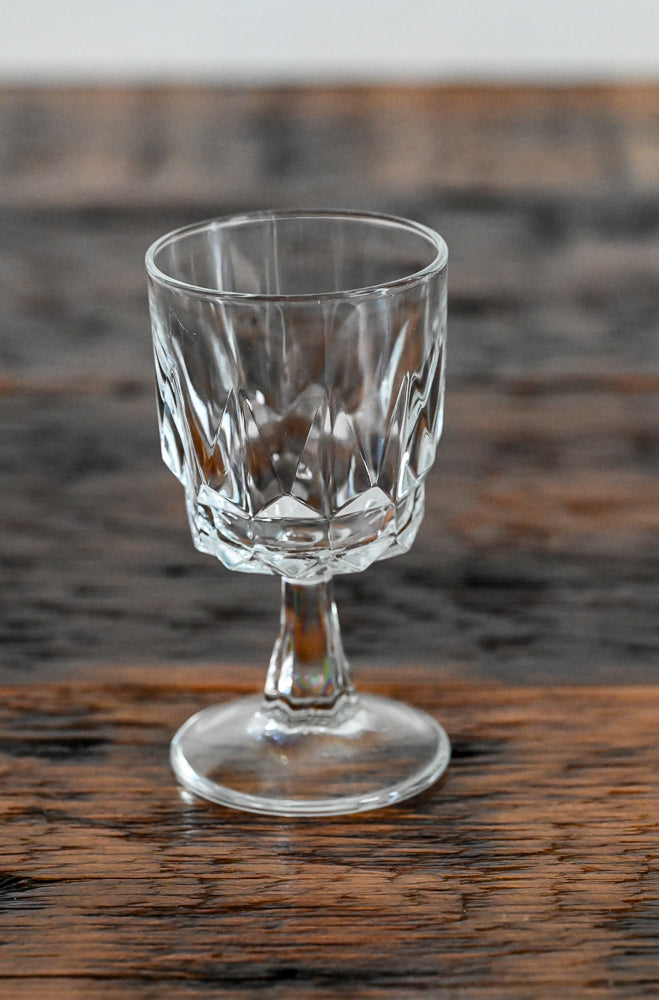clear stemmed wine glass on wood table