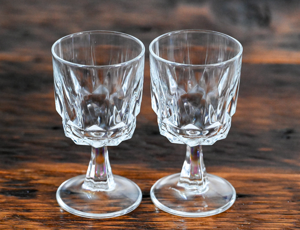 clear stemmed wine glasses on wood table