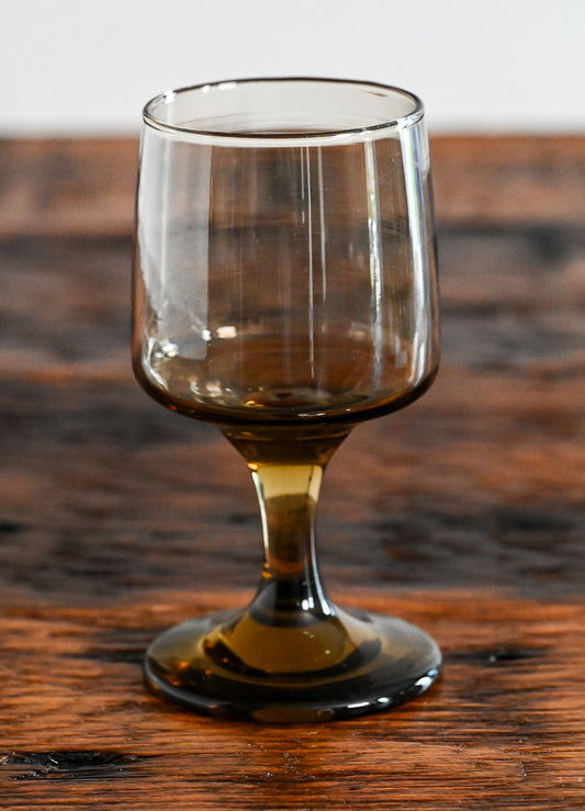 Libbey brown footed glass on wood table