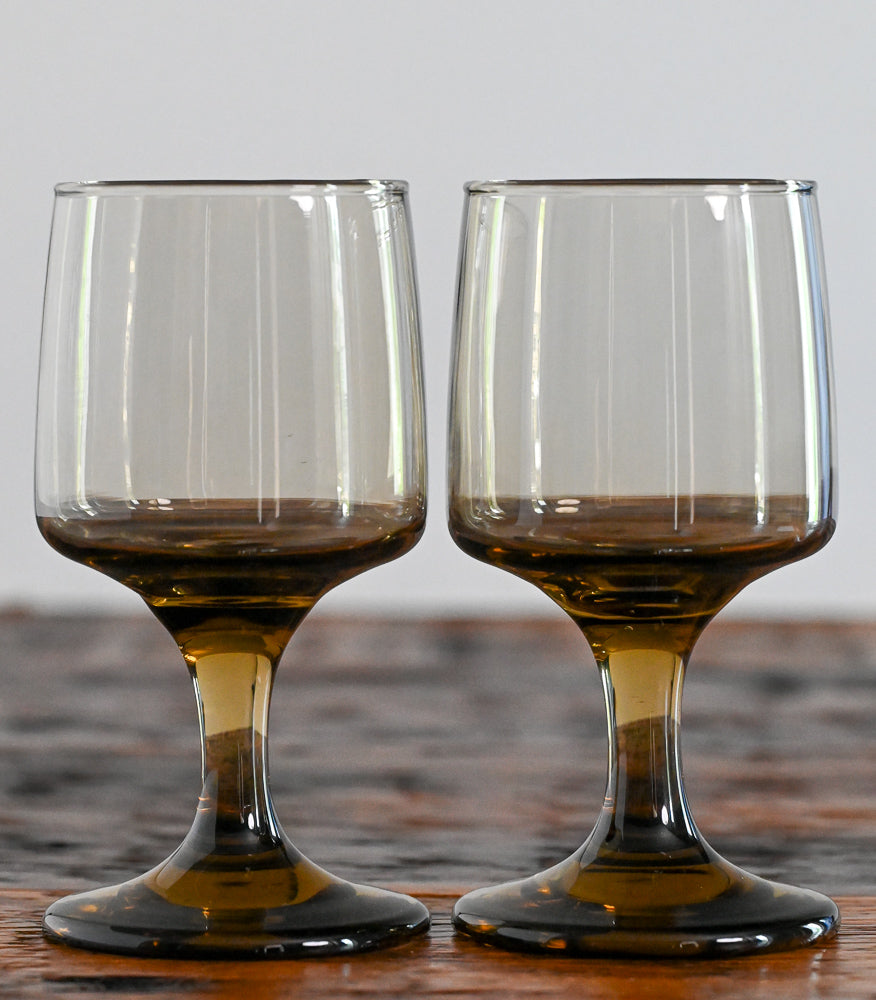 brown footed glasses on wood table