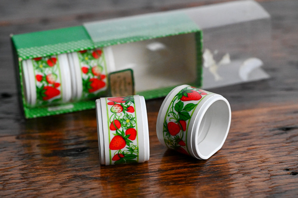 white plastic strawberry napkin rings in original container