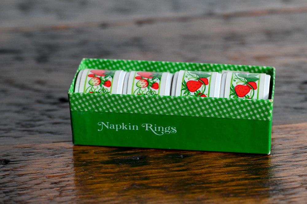 white plastic strawberry napkin rings in original container