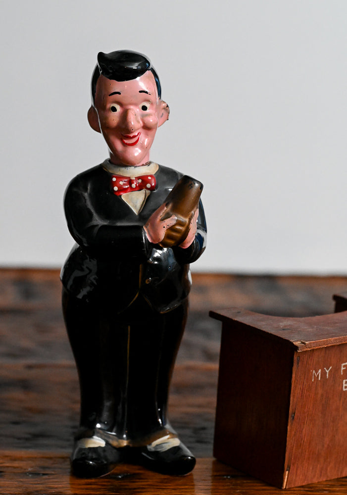 bartender holding a shaker behind a wooden bar decanter, head is the stopper