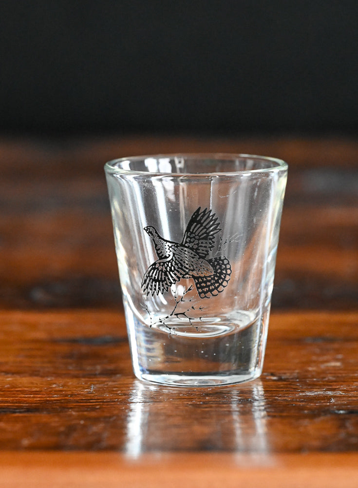 black print grouse on clear shotglass