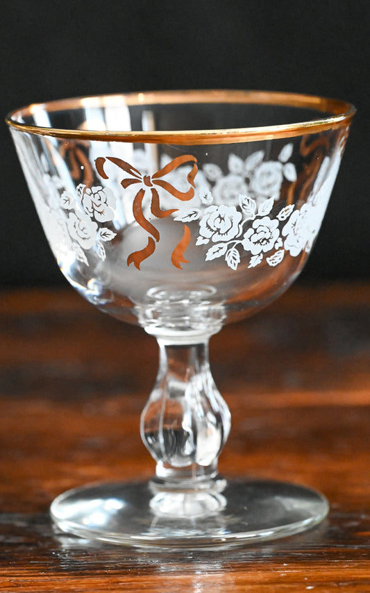 white roses and gold bow, gold rim cocktail coupe