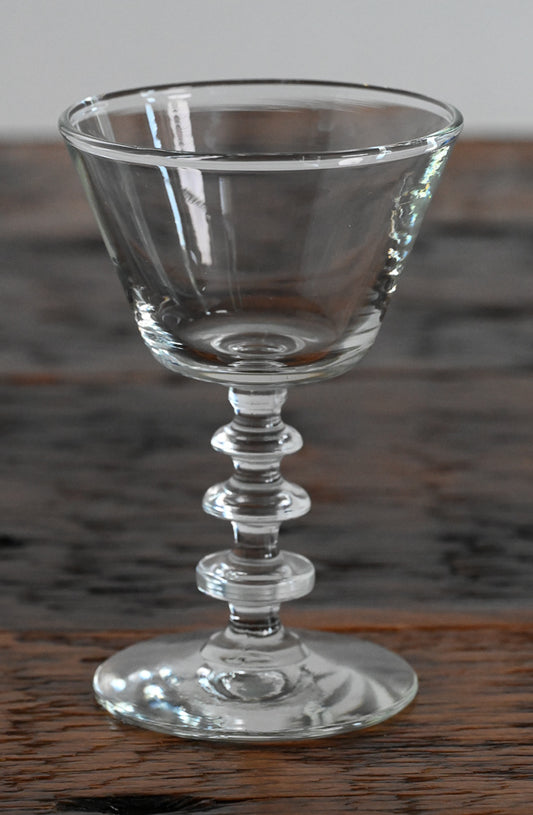 glass coupe with stacked stem on wood table