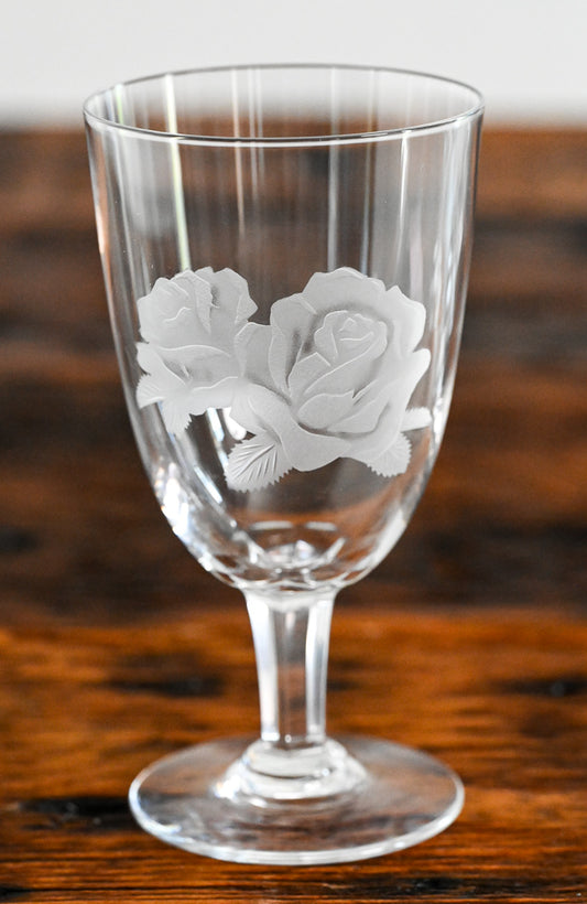 rose etched water goblets on wood table