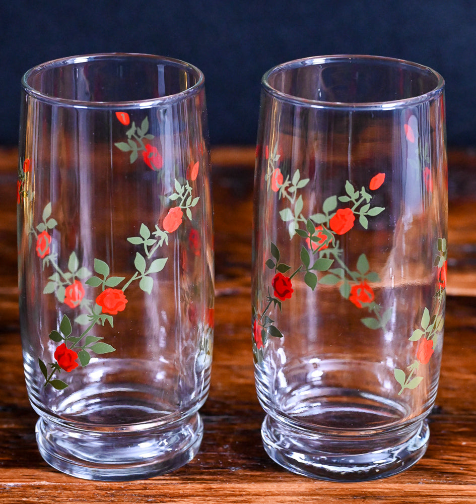 red roses on green vines on clear tall cooler glasses