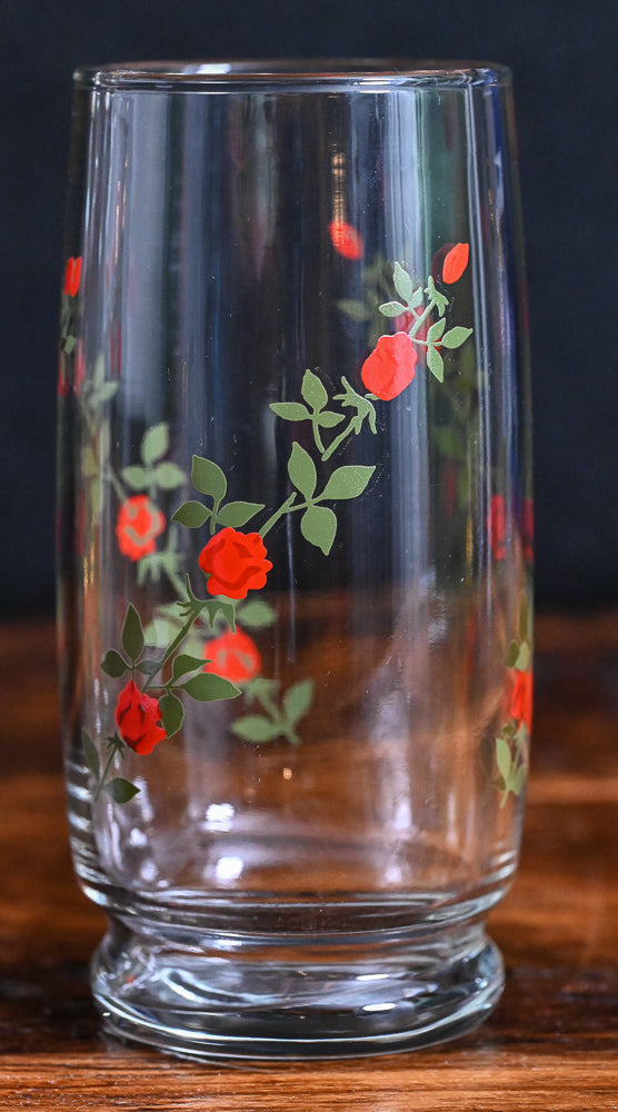 red roses on green vines on clear tall cooler glasses