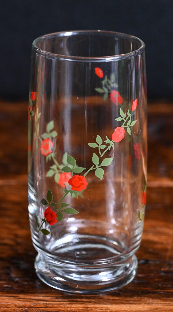 red roses on green vines on clear tall cooler glasses