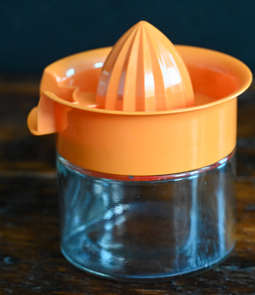 Orange plastic and glass citrus reamer