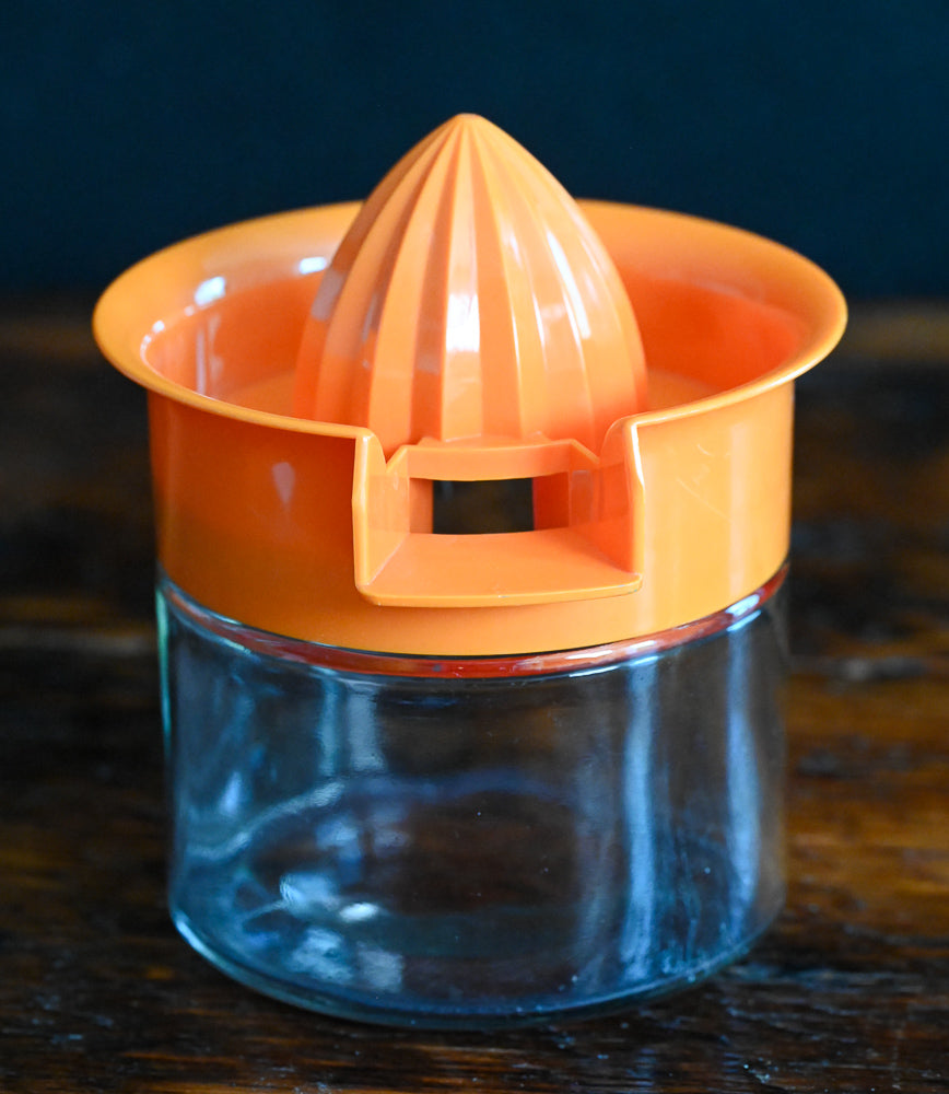 orange plastic and glass citrus reamer