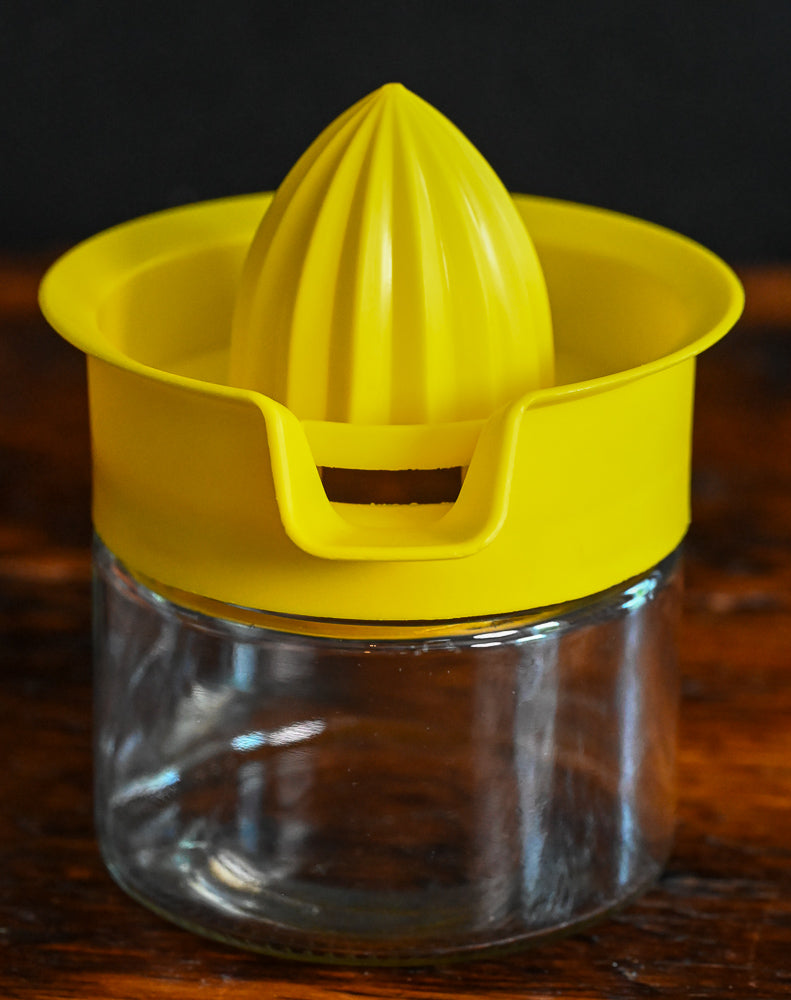 yellow plastic and glass citrus reamer