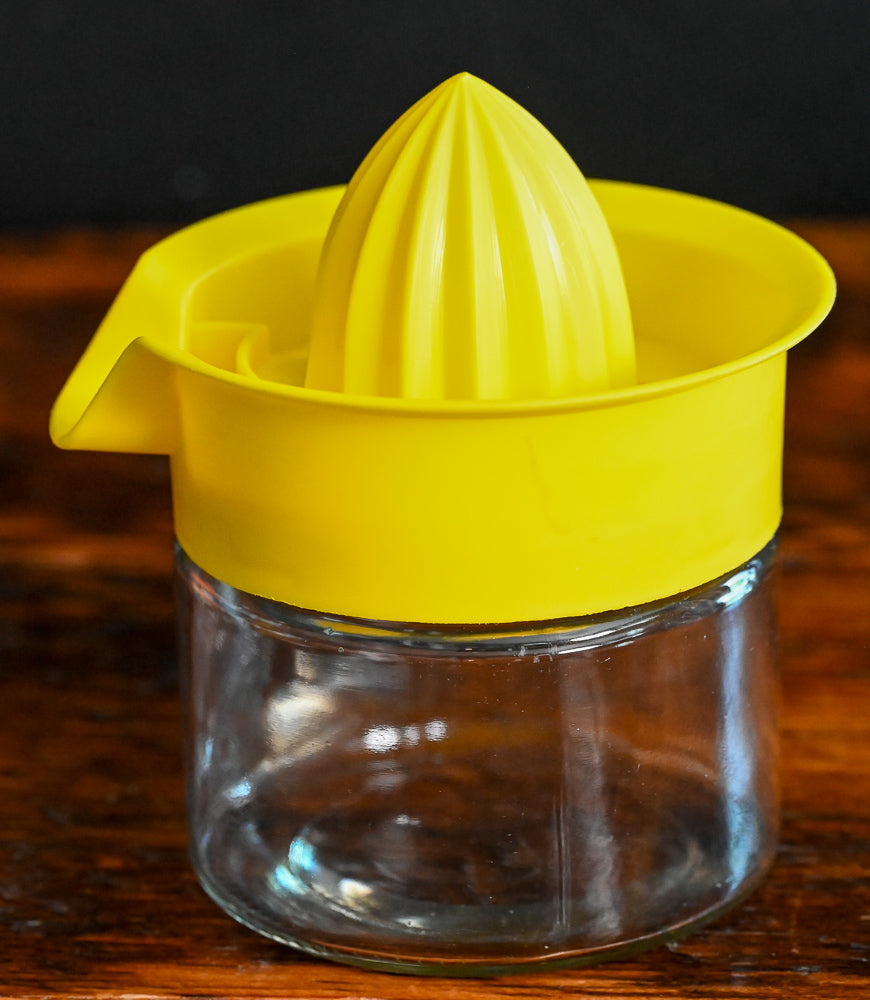 yellow plastic and glass citrus reamer