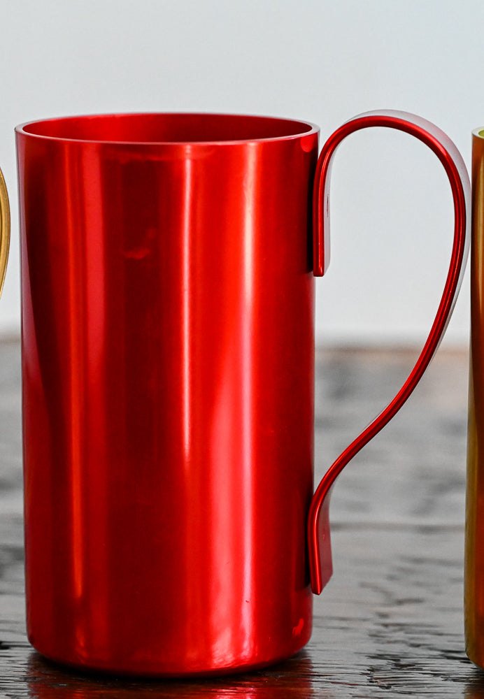 red metal mug on wooden table