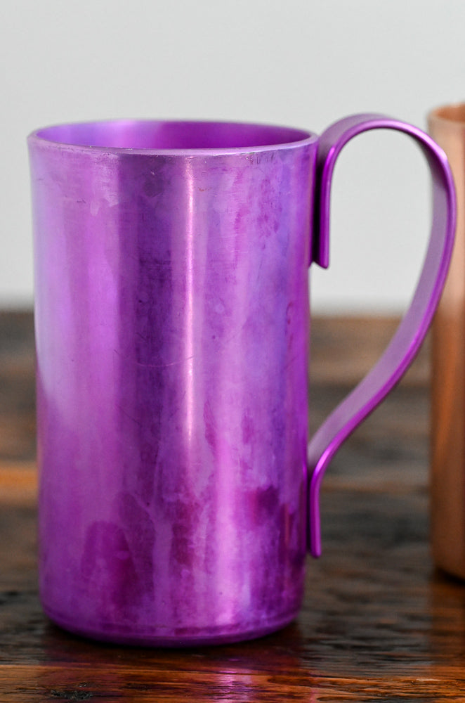 purple metal mug on wooden table
