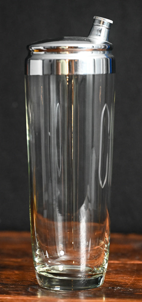 Clear glass cocktail shaker monogrammed with "CNH", metal lid