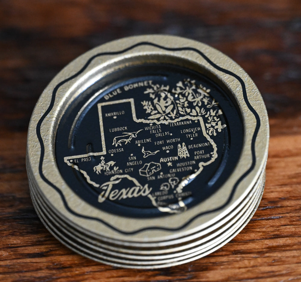 gold and black metal souvenir Texas coasters