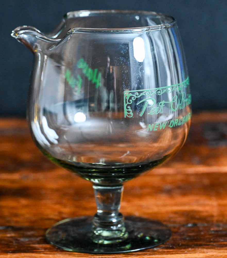 smokey grey mixing glass with green Pat O'Brien's written on it