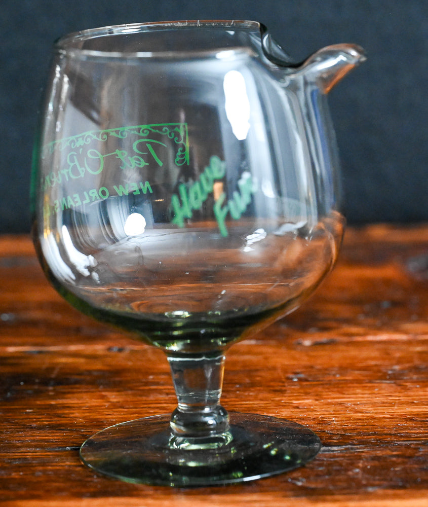 smokey grey mixing glass with green Pat O'Brien's written on it