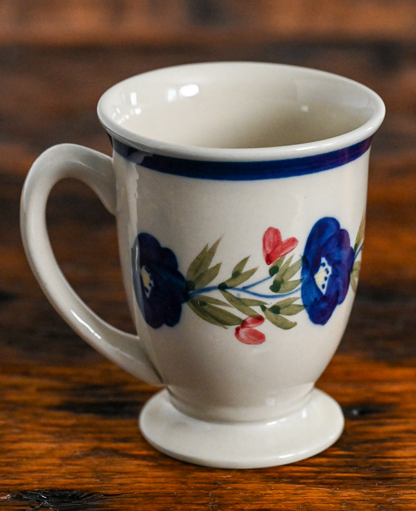 tan pedestal mug with blue and pink flowers